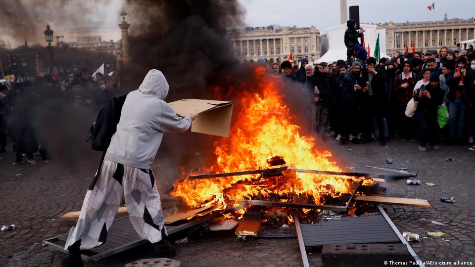 Πλήθος διαδηλωτών γύρω από μία φωτιά με τυχαία αντικείμενα και απορρίμματα στην Γαλλία.